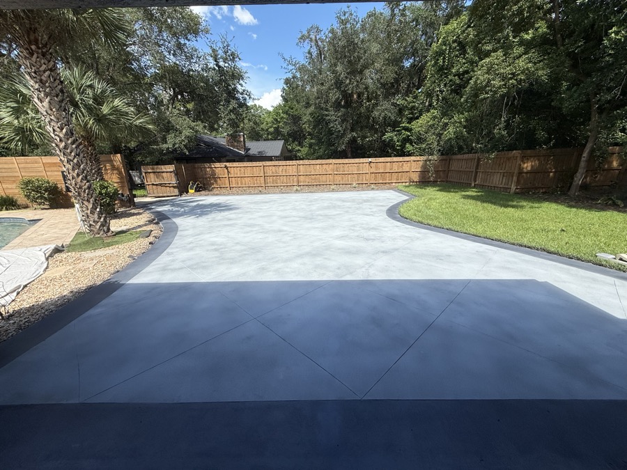 Driveway resurfaced with a light gray PetraReGen finish, dark borders and decorative control-line detailing
