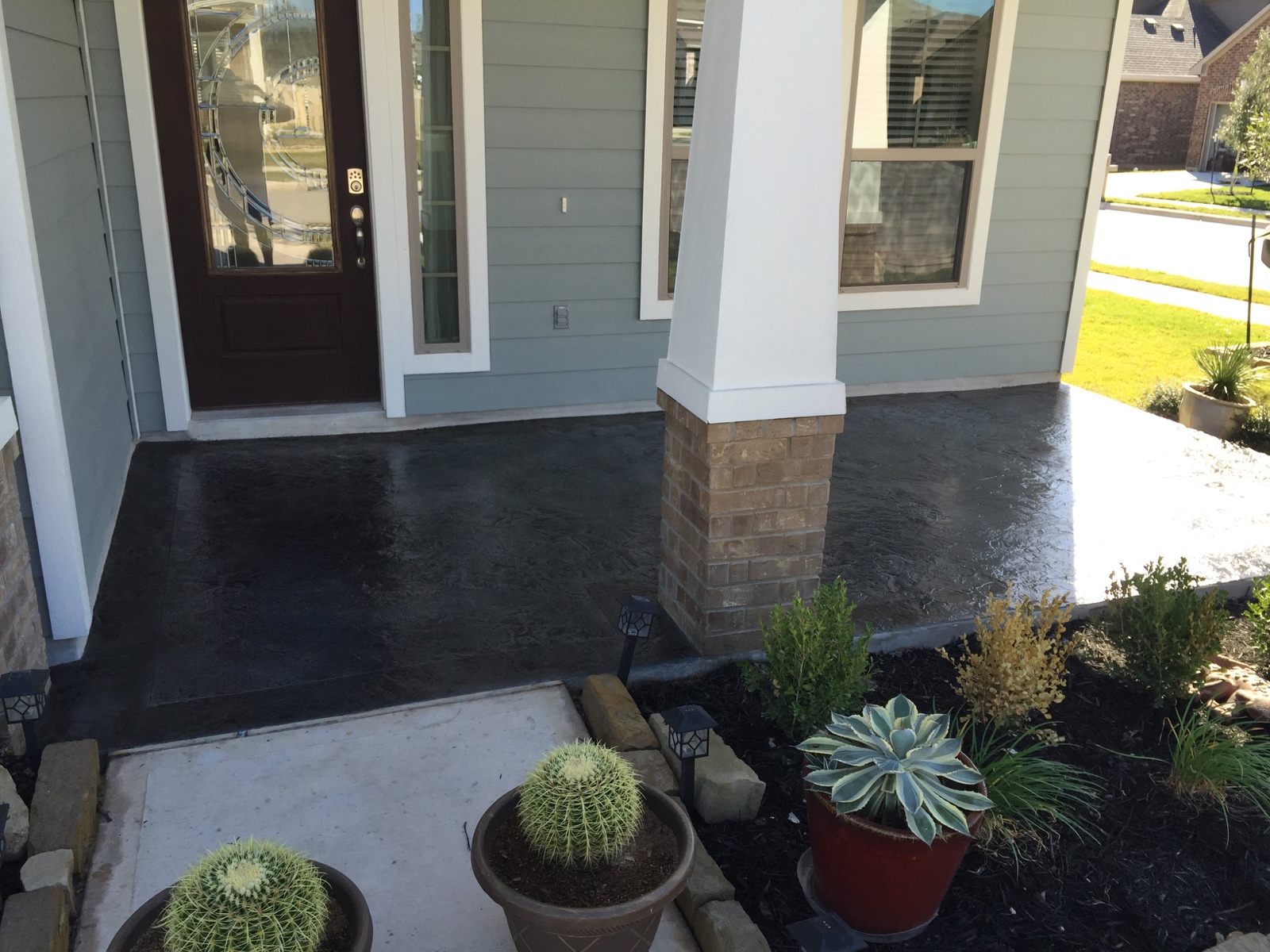 Residential porch after application of a dark gray PetraStamp textured finish